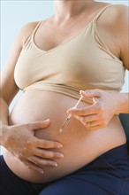 Pregnant woman injecting belly. Photographe : Jennifer L. Boggs