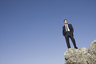 Businessman standing on edge of cliff. Photographe : PT Images