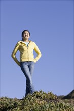 Teenage girl standing on hill. Photographe : PT Images
