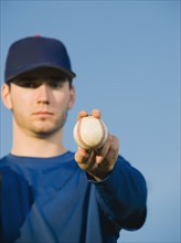Baseball player holding ball.