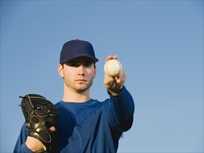 Baseball player holding ball.