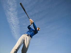 Baseball player swinging bat.