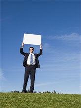 Businessman holding blank sign.
