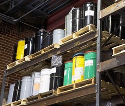 Paint cans on warehouse shelf. Photographe : fotog