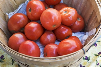 Tomatoes in a basket at a fruit stand. Photographe : fotog