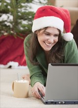 Woman using laptop at Christmas. Photographe : Jamie Grill