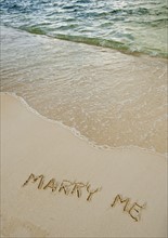 Marry me message written in sand.