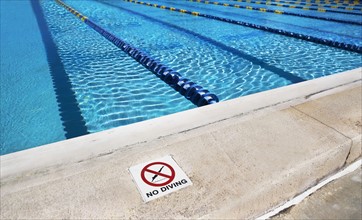 No diving sign on edge of swimming pool. Photographe : fotog