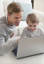Father and son looking at laptop.