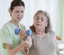 Physical therapist helping senior woman.