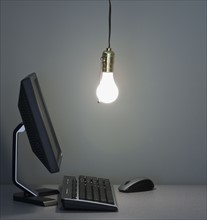 Light bulb hanging over computer.