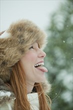 Woman catching snow on tongue.