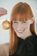 Woman holding Christmas ornament.