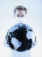 Scientist holding black and white globe.
