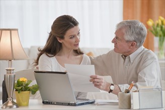 Daughter helping senior father with bills.