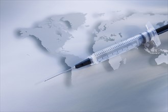 Syringe on world map.