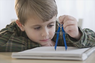 Boy using drawing compass.