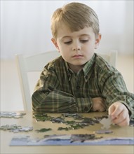 Boy assembling puzzle.