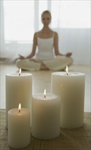 Woman meditating with candles.