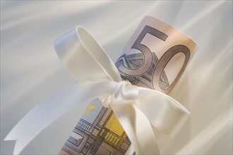 50 euro note wrapped in ribbon.
