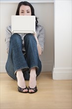 Woman using laptop on floor.