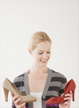 Young woman choosing high heel shoes. Photographe : Jamie Grill
