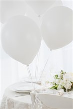 Balloons at wedding table setting, studio shot. Photographe : Jamie Grill