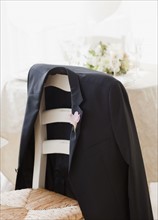 Grooms suit jacket on chair at wedding, studio shot. Photographe : Jamie Grill