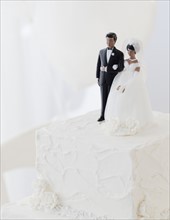 Bride and groom cake toppers on wedding cake. Photographe : Jamie Grill