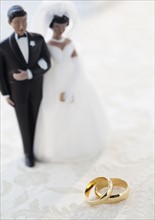 Wedding rings by bride and groom cake toppers. Photographe : Jamie Grill