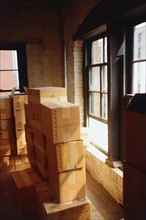 Stacked cardboard boxed in house. Photographe : Stewart Cohen