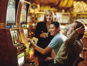 People in casino playing on slot machines. Photographe : Stewart Cohen