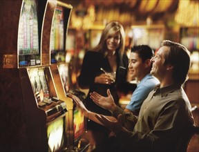 People in casino playing on slot machines, Las Vegas, Nevada, USA. Photographe : Stewart Cohen
