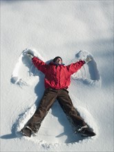 Woman making snow angel. Photographe : John Kelly