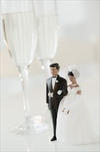 Bride and groom cake toppers by champagne glasses. Photographe : Jamie Grill