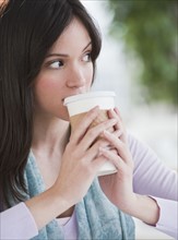 Mid-adult woman drinking from plastic cup.