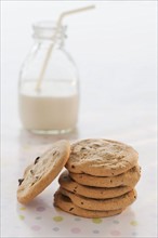 Stack of cookies with milk on table.