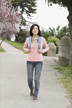 Young woman walking in park, San Francisco, California, USA. Photographe : PT Images