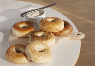 Bagels and creme cheese on table.