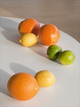 Limes, citruses and oranges on table.