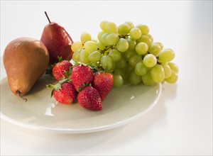 Pears, grapes and strawberries on plate.