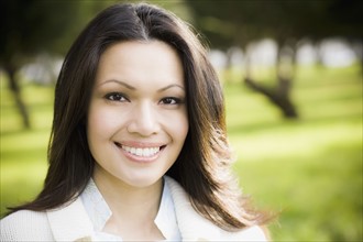 Portrait of woman smiling in park. Photographe : PT Images