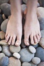 Woman's feet on pebbles.