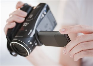 Woman using digital camcorder, close-up.