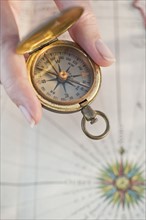 Close-up of woman holding antique compass.