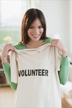 Mid-adult woman showing t-shirt reading Volunteer.