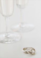 Two wedding rings by wineglasses. Photographe : Jamie Grill