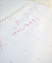 Close-up of holiday written on calendar. Photographe : Jamie Grill