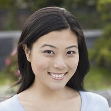 Portrait of young woman smiling, outdoors. Photographe : PT Images