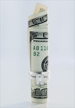 One hundred dollar bill rolled up in wedding ring. Photographe : Jamie Grill